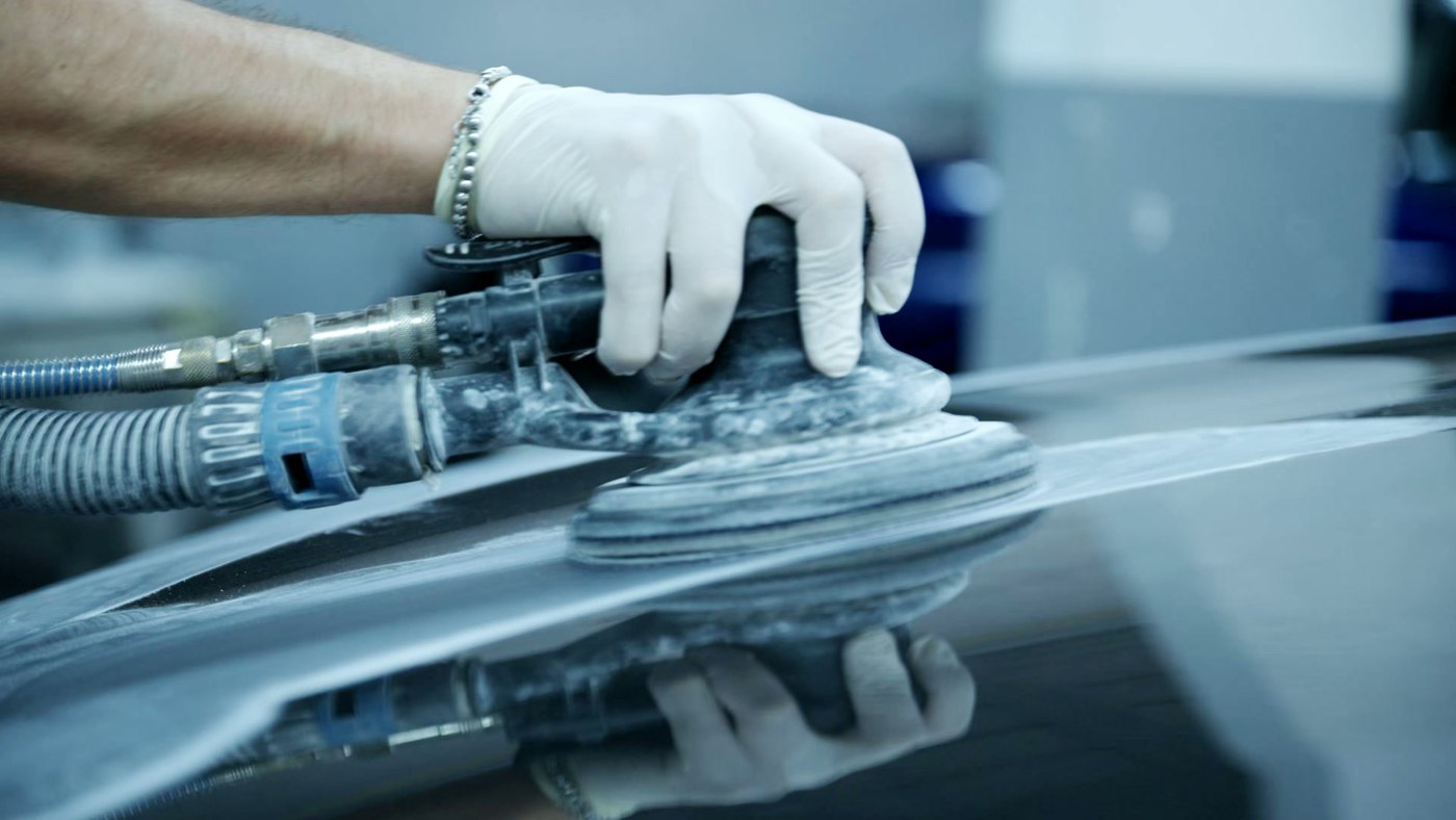 Cezary sanding a car panel by hand during a body repair in Stoke-on-Trent