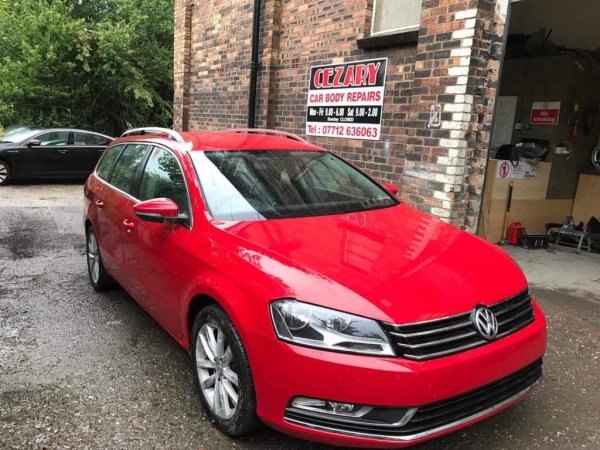 Red Volkswagen Passat outside the Cezary Car Body Repairs signage