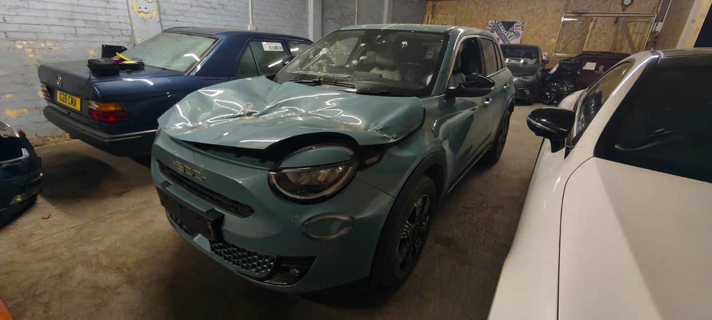 Repaired grey electric car front end in the workshop