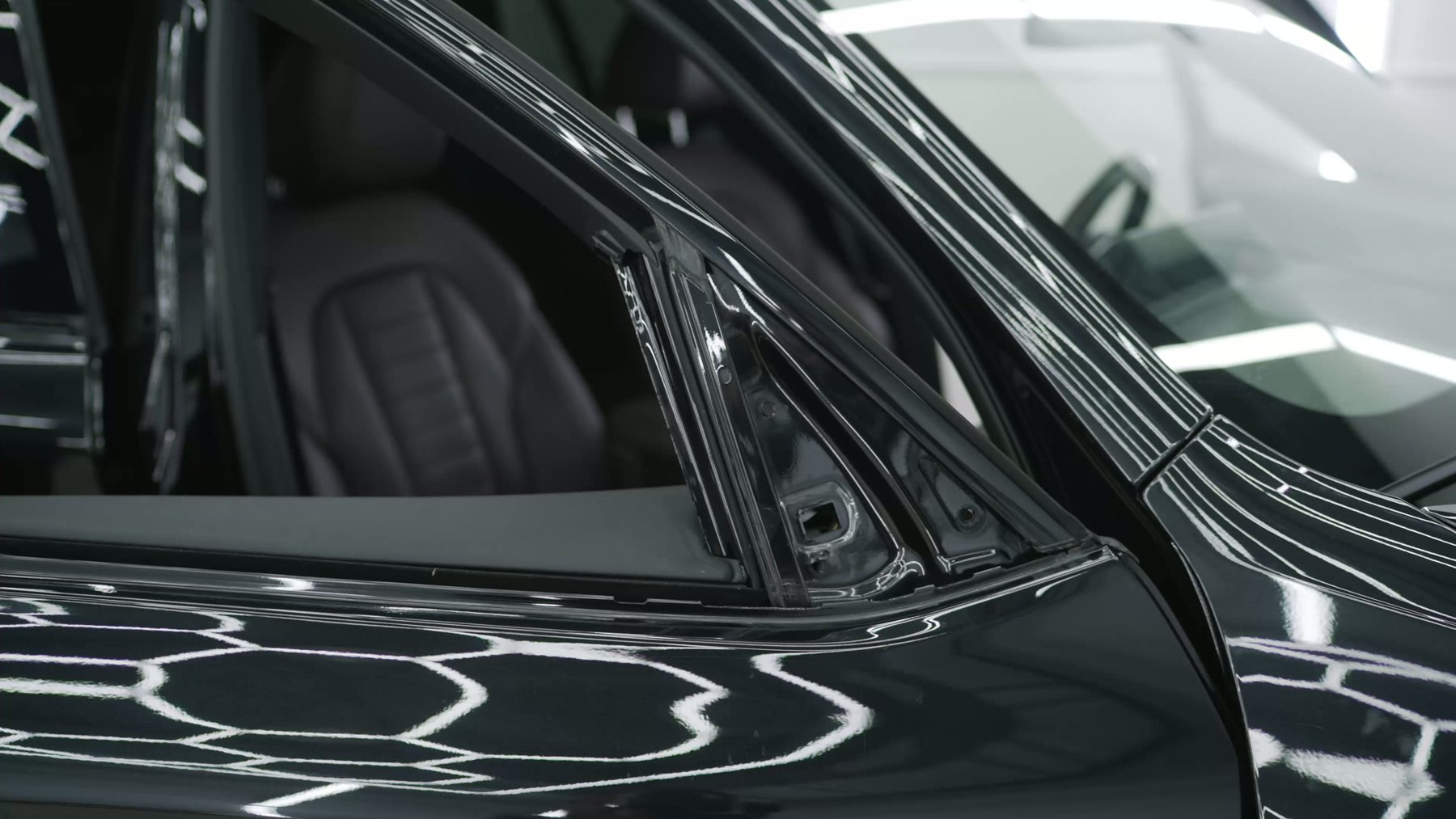 Polished dark car bodywork reflecting light after a Cezary repair